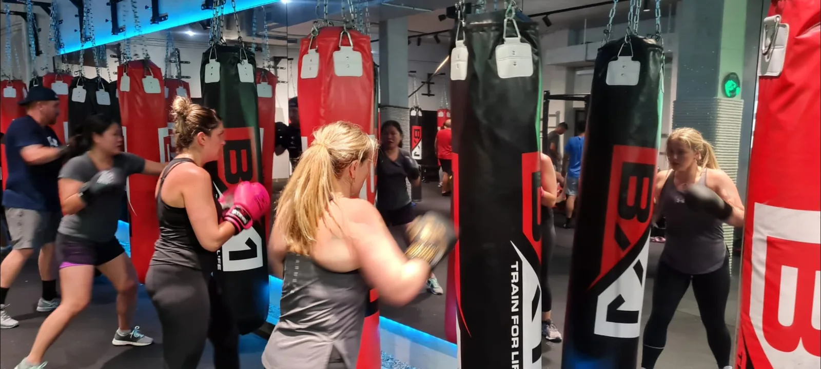 Women training on boxing bags during a BoxFit class at BX1 Gym