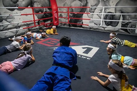 Children playing martial arts birthday party games inside the BX1 boxing ring
