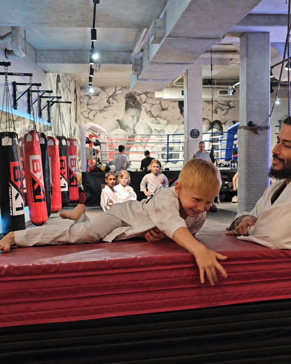 Young child smiling during a supervised BX1 school holiday obstacle-course activity